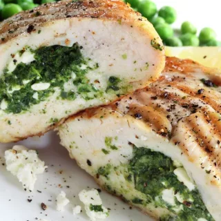 Spinach and Mushroom Stuffed Chicken Breast on a plate served with peas